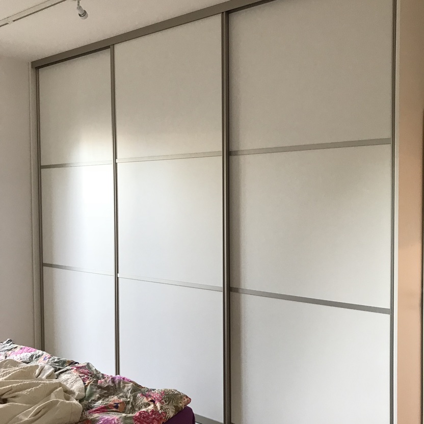 Kleiderschrank nach Maß mit weißen Schiebetüren und Beleuchtung