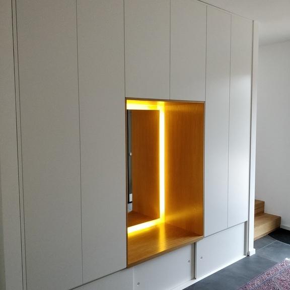 Garderobe nach Maß Garderobe nach Maß mit beleuchtetem Element in der Mitte und weißen Fronten