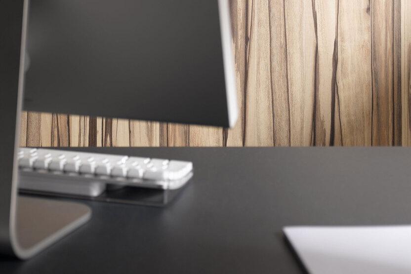 Detailaufnahme einer Hotelrezeption mit Holzhintergrund Detailaufnahme einer Hotelrezeption mit Holzhintergrund naturgemasert und Computer